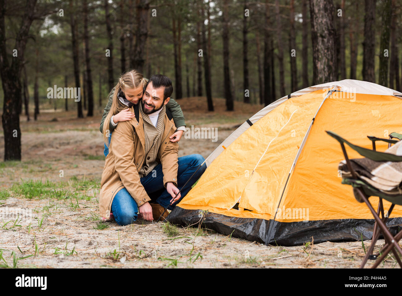 happy father and daughter installing tent for camping Stock Photo