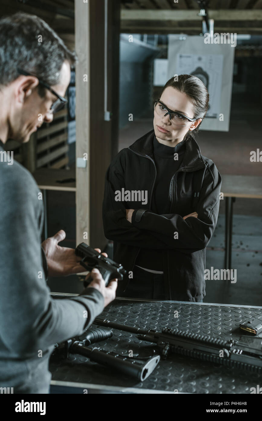 Gun Range Instructor instructor holding gun in shooting range Stock Photo - Alamy