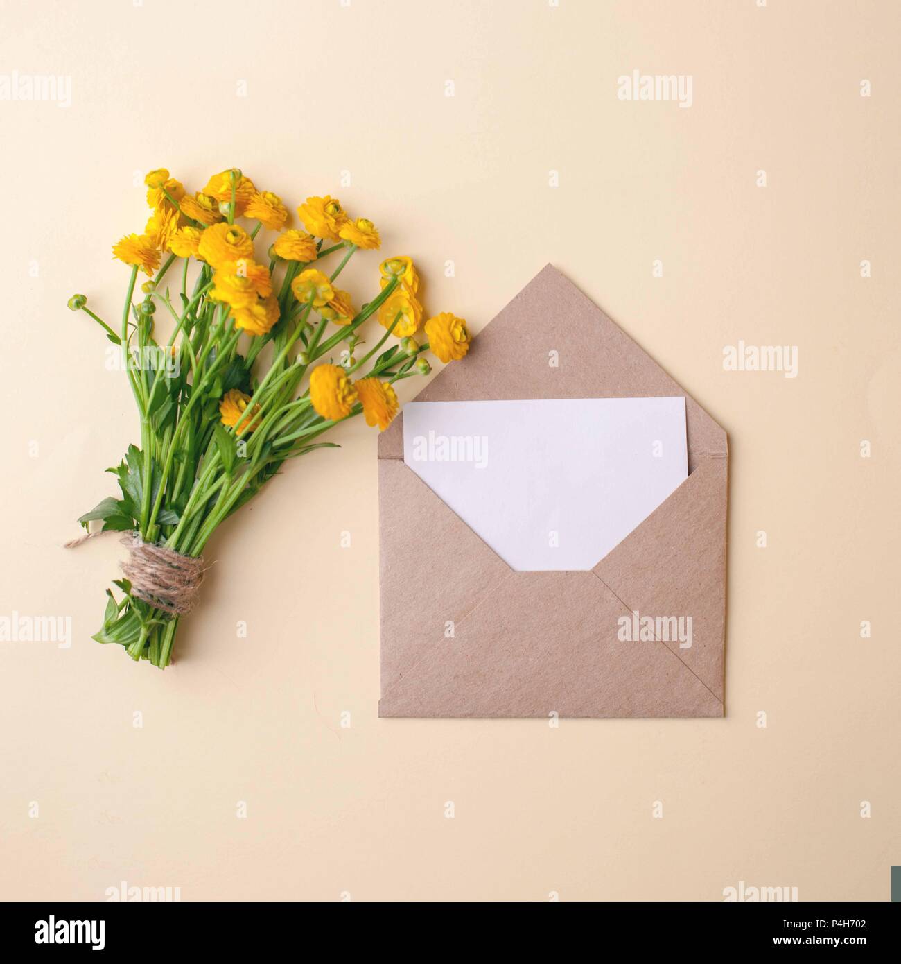 Bouquet of yellow flowers and blank on pastel background, beautiful breakfast, vintage romantic card, top view, flat lay, rustic style, muted colors Stock Photo
