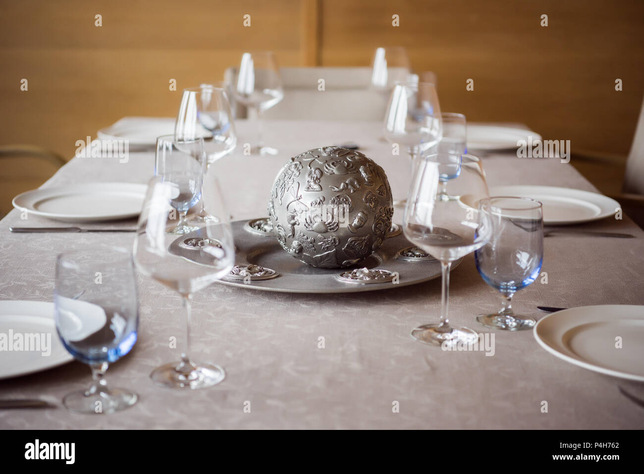 close up view of arrangement of cutlery, decorations and empty wineglasses on table in restaurant Stock Photo