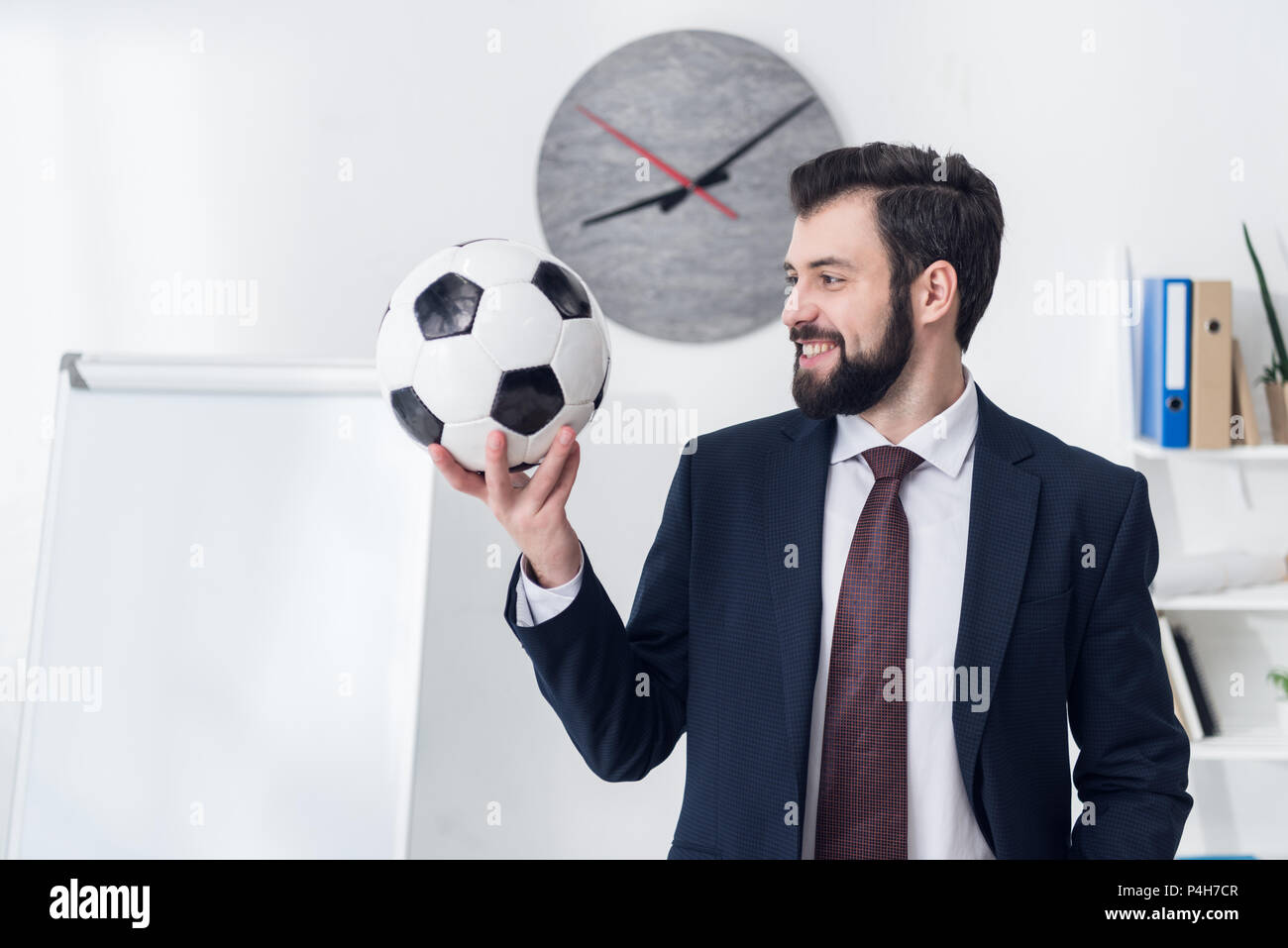 portrait of smiling businessman holding soccer ball in office Stock ...