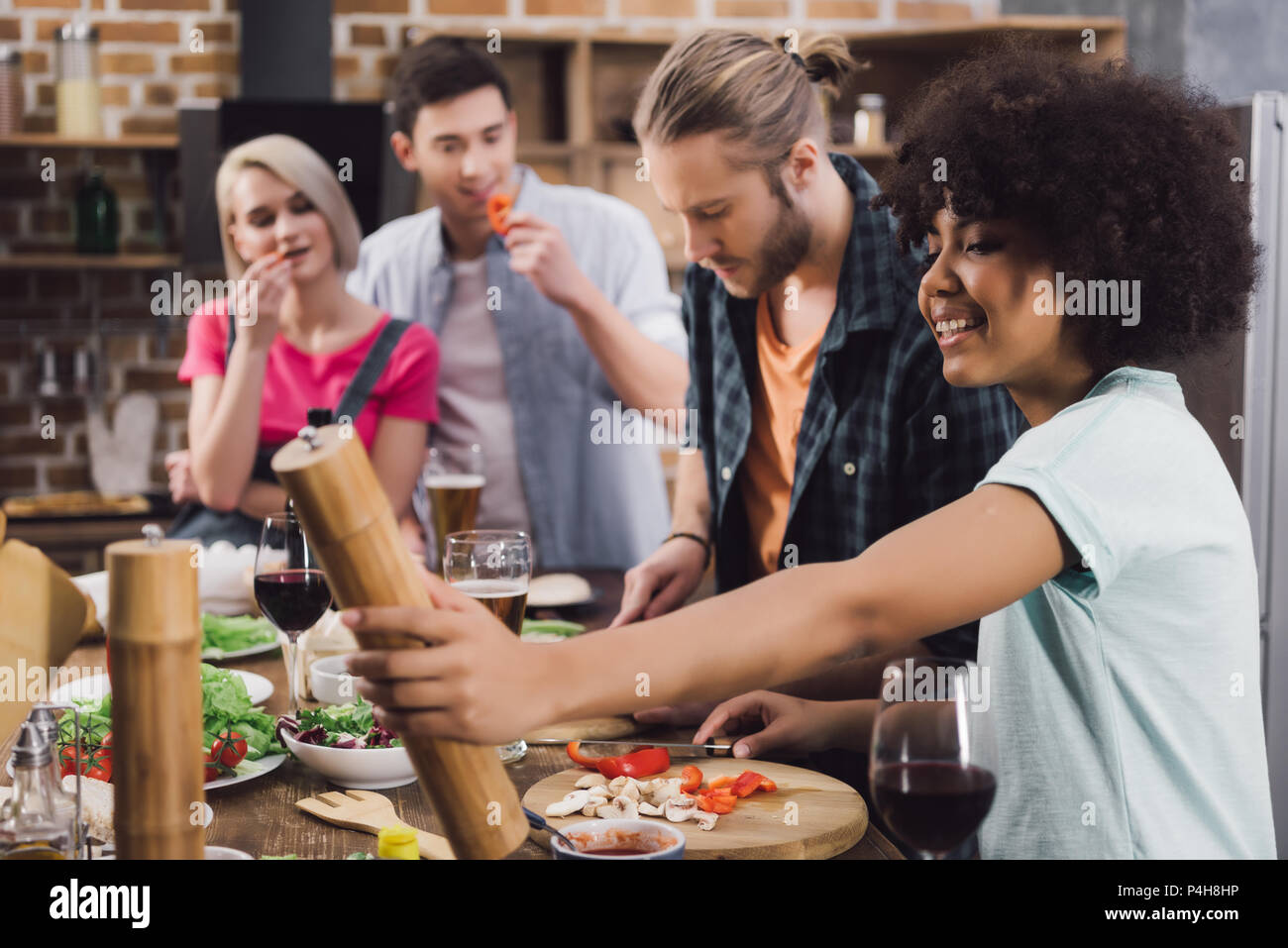 multiethnic friends preparing food together in kitchen Stock Photo