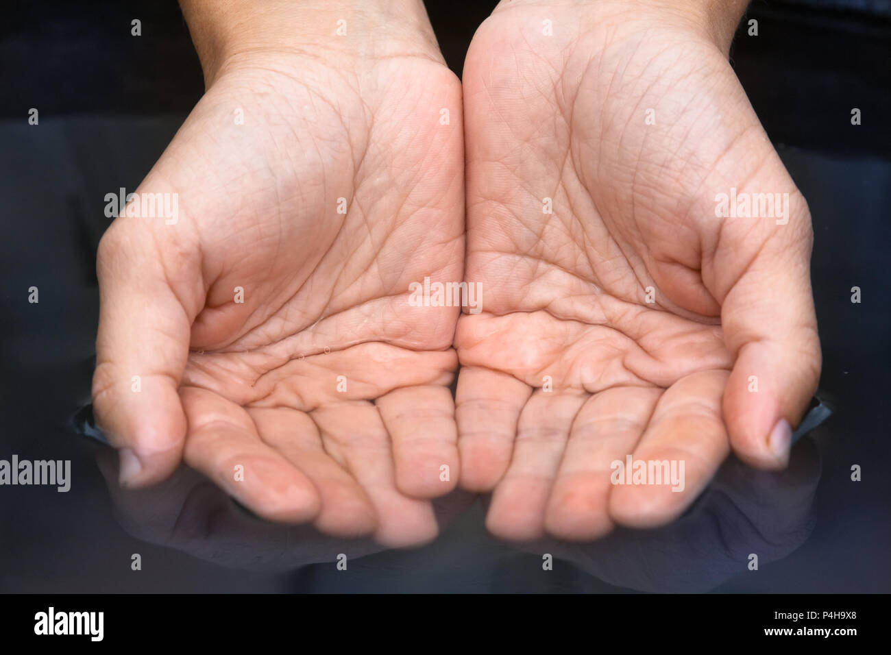 hand scooping clean fresh water from a pond Stock Photo
