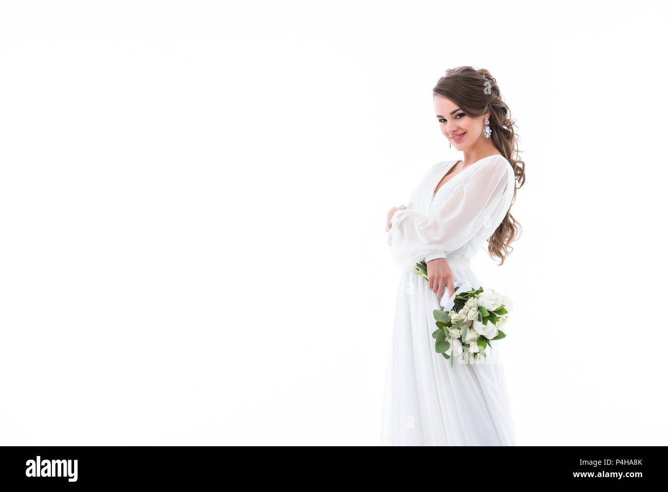 smiling bride posing in white traditional dress with wedding bouquet ...