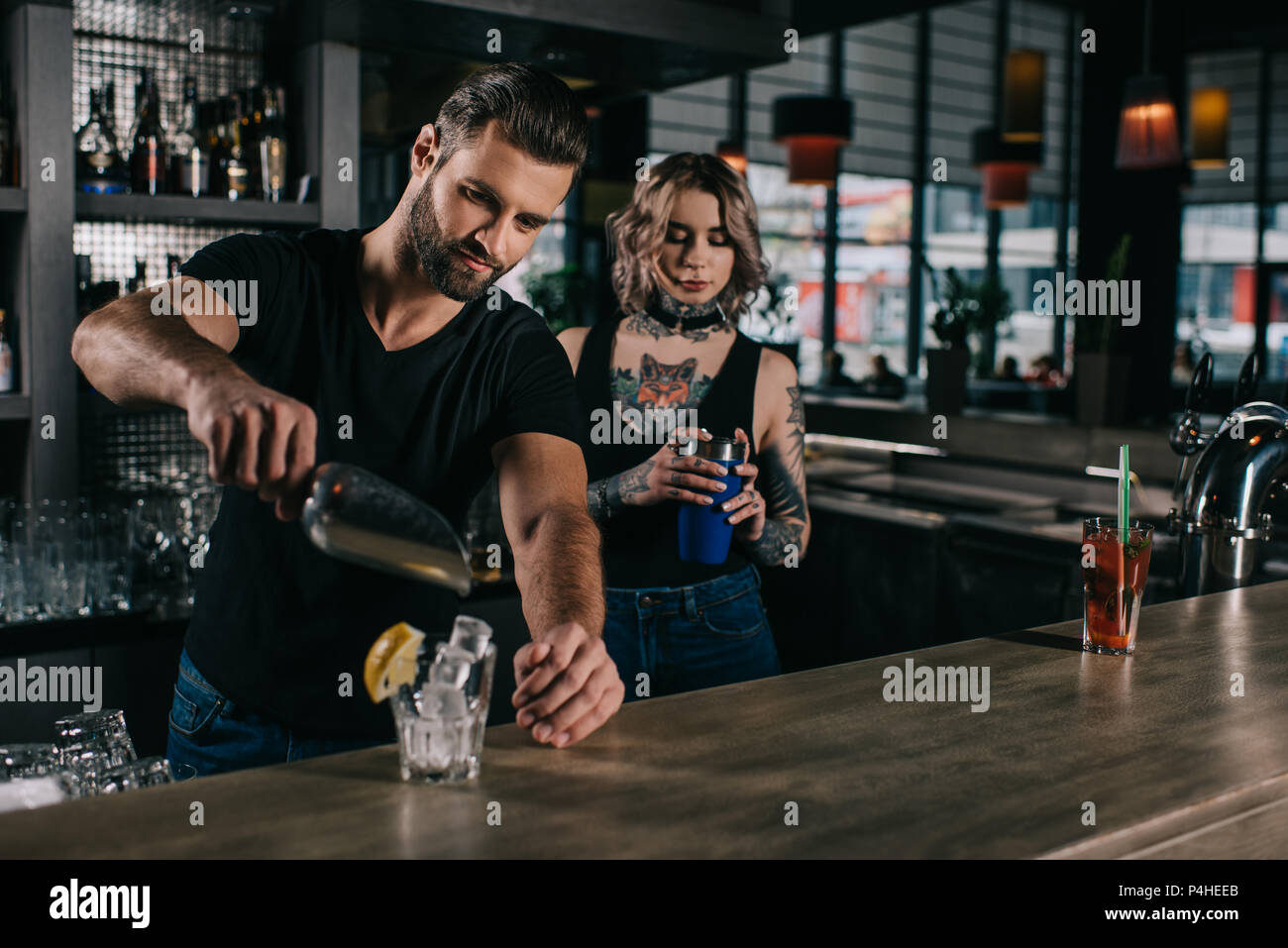 young bartenders preparing alcohol drinks at bar counter Stock Photo