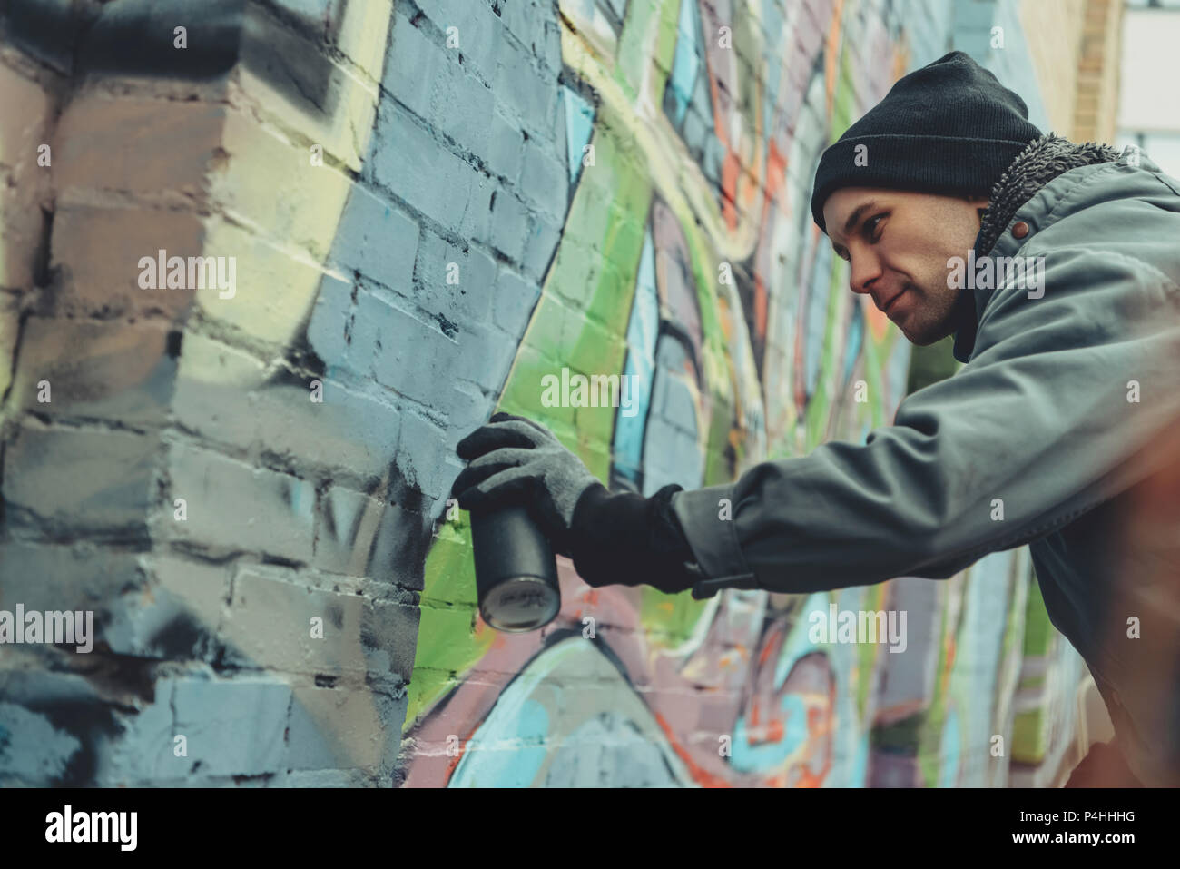 male street artist painting colorful graffiti on wall Stock Photo - Alamy