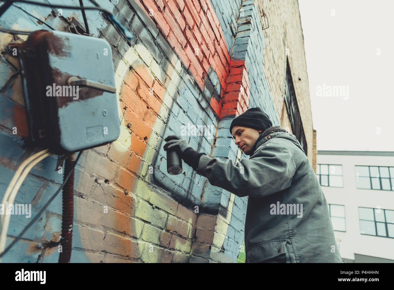 street artist painting colorful graffiti on wall Stock Photo - Alamy