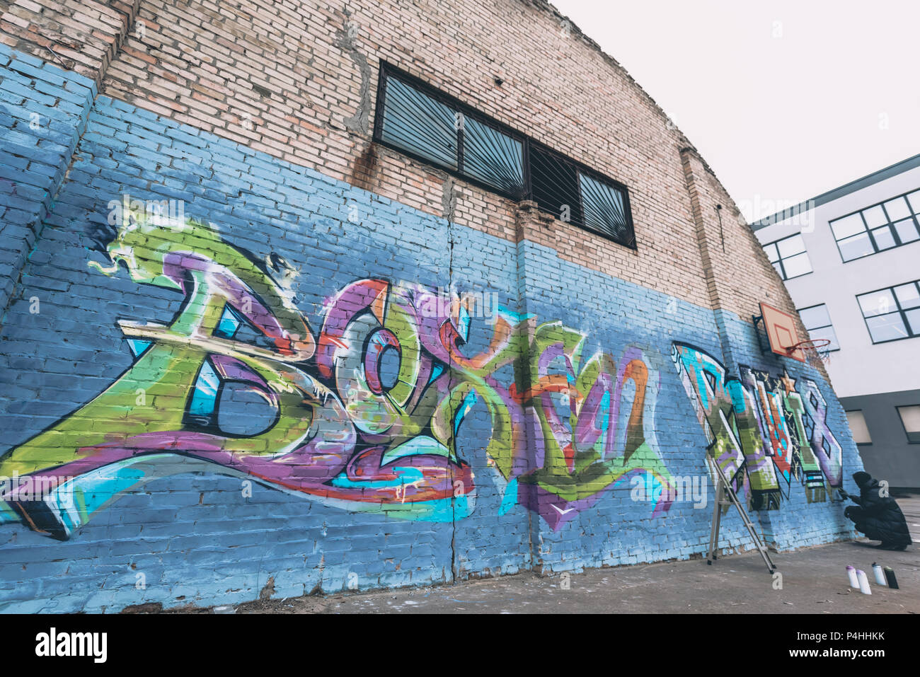 street artist painting colorful graffiti on wall Stock Photo - Alamy