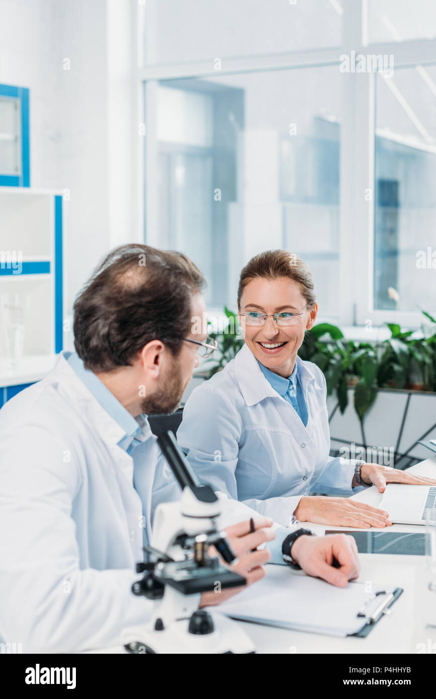 scientific researchers in white coats working together at workplace in ...
