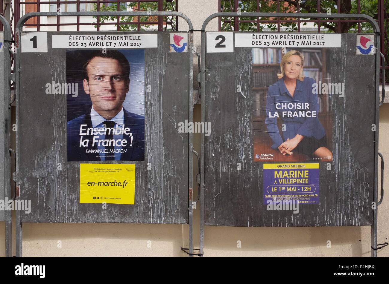 April 29, 2017 - Paris, France: Defaced electoral posters of both French presidential candidates Emmanuel Macron and Marine Le Pen, put up near a ballot centre before the run-off.  Affiches electorales officielles pour le deuxieme tour de la presidentielle. Stock Photo