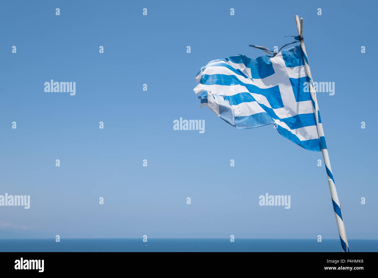 Weathered Greek flag blowing in the wind. Stock Photo