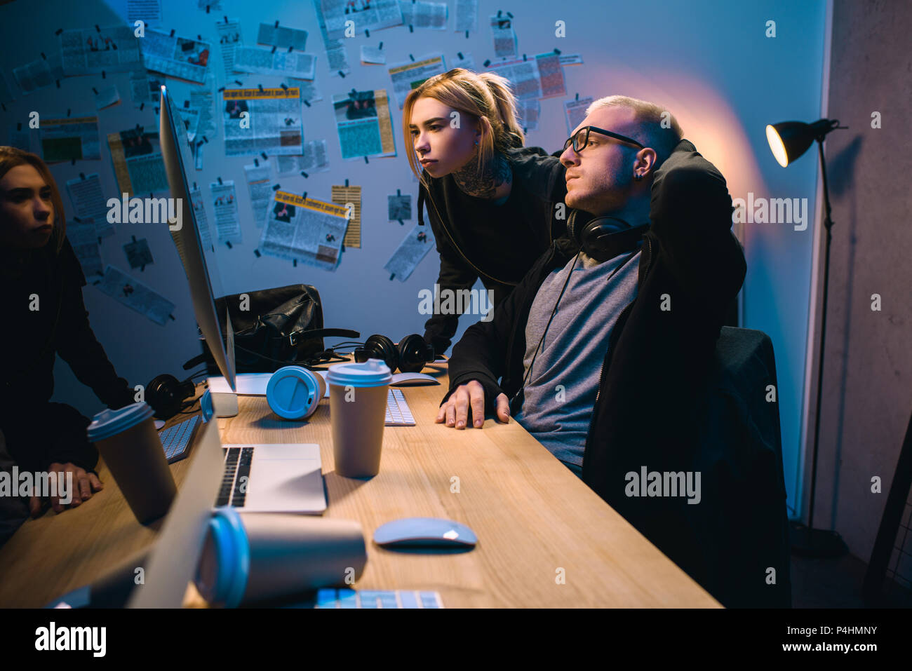 couple of hackers looking at computer screen together in dark room ...