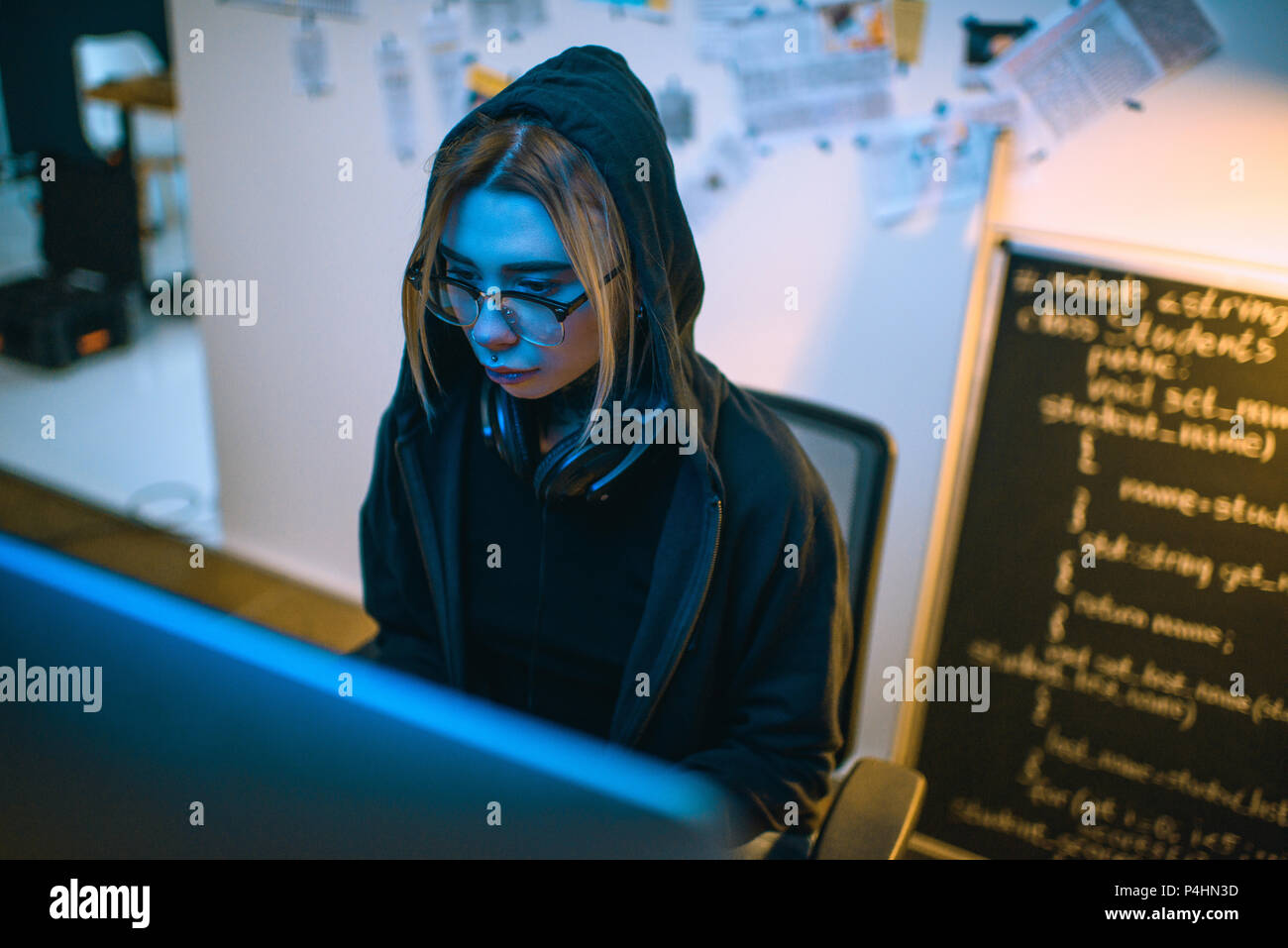 high angle view of female hacker developing malware under blue light Stock Photo