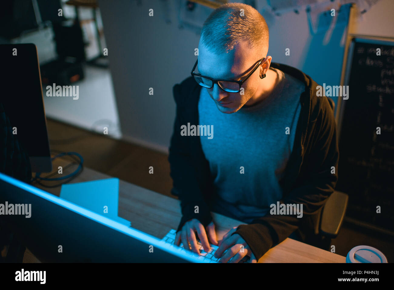 high angle view of hacker developing malware in dark room Stock Photo