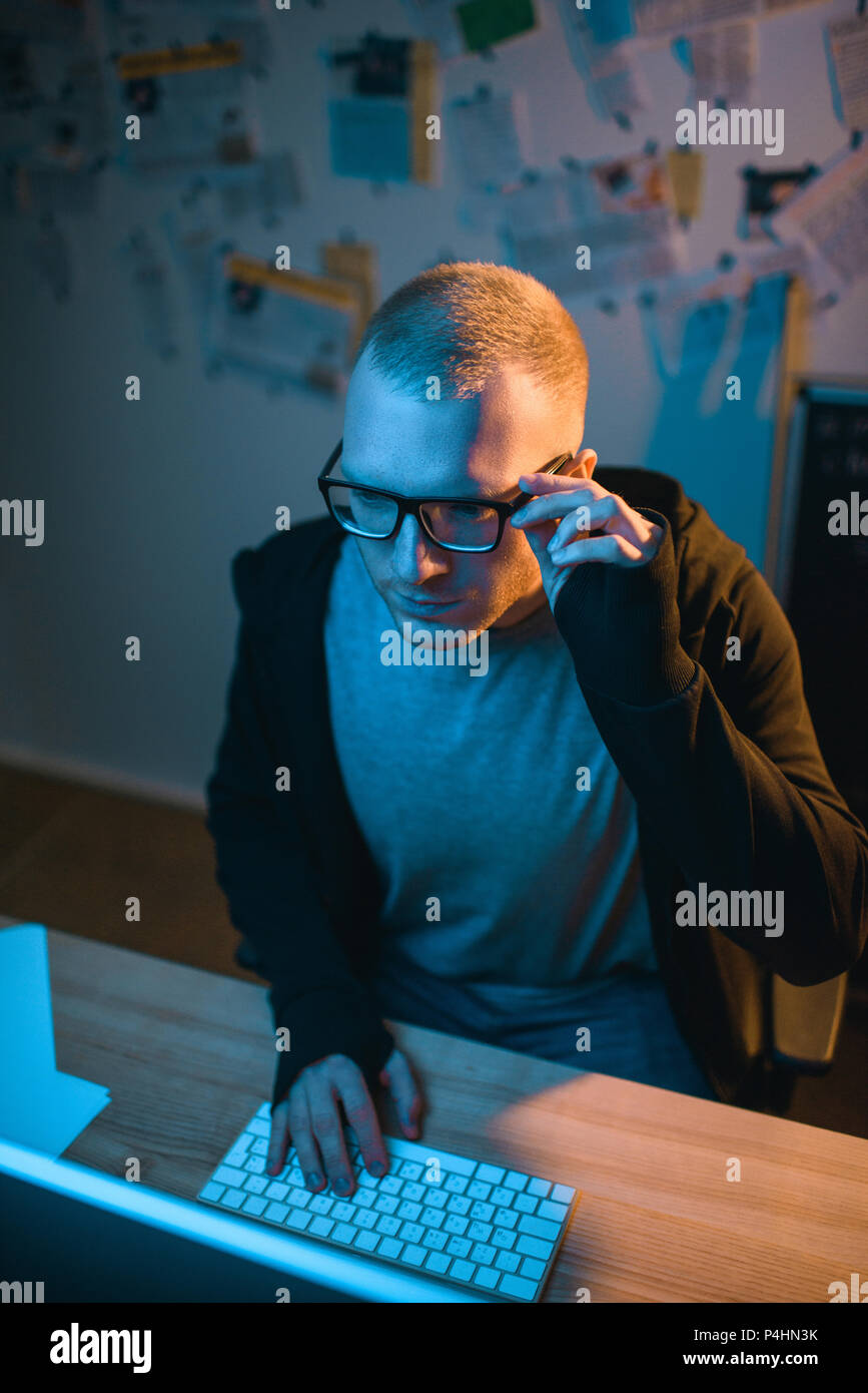 high angle view of serious hacker developing malware in dark room Stock Photo