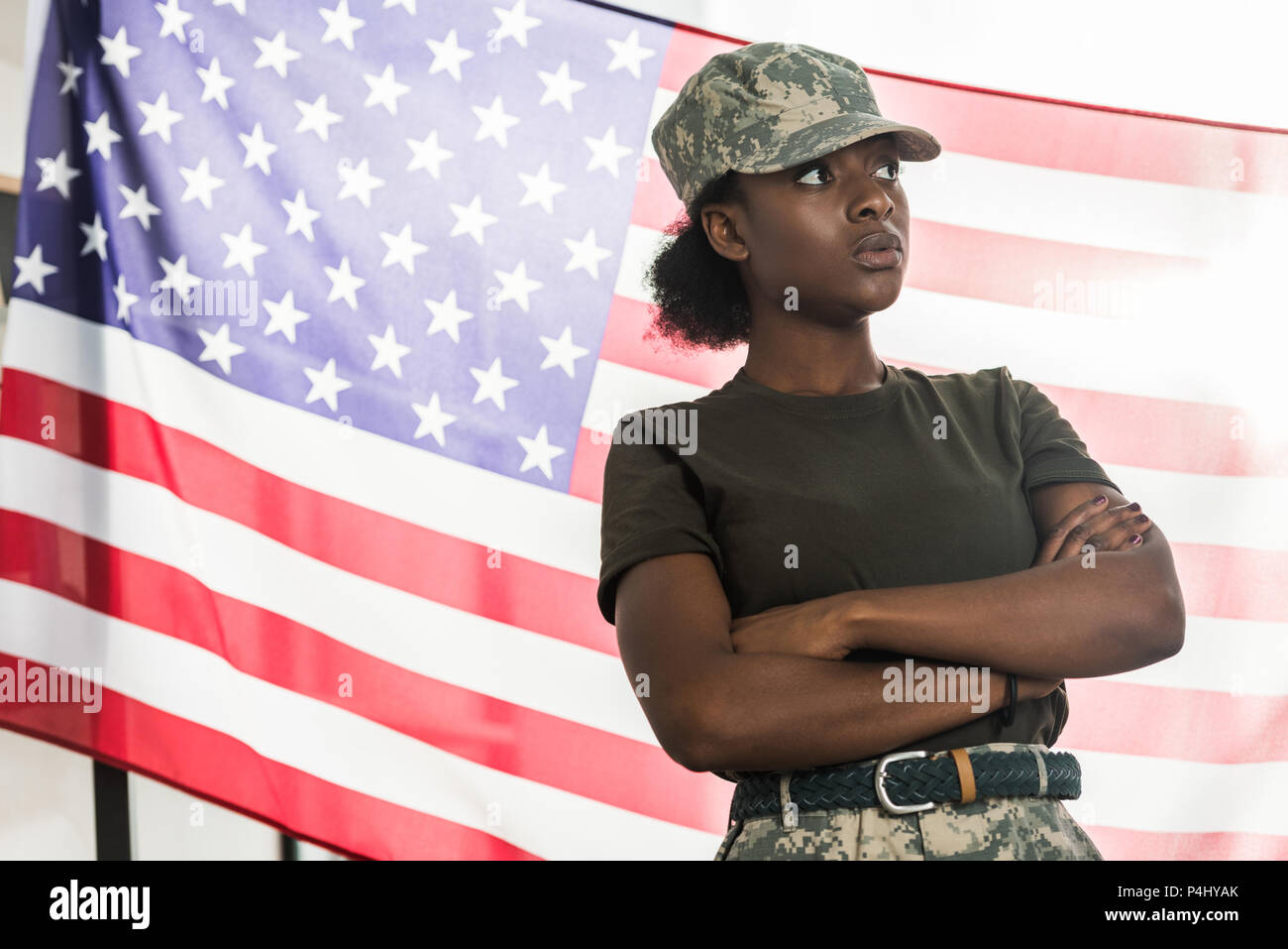 Female african american army soldier in camouflage clothes in front of us flag Stock Photo