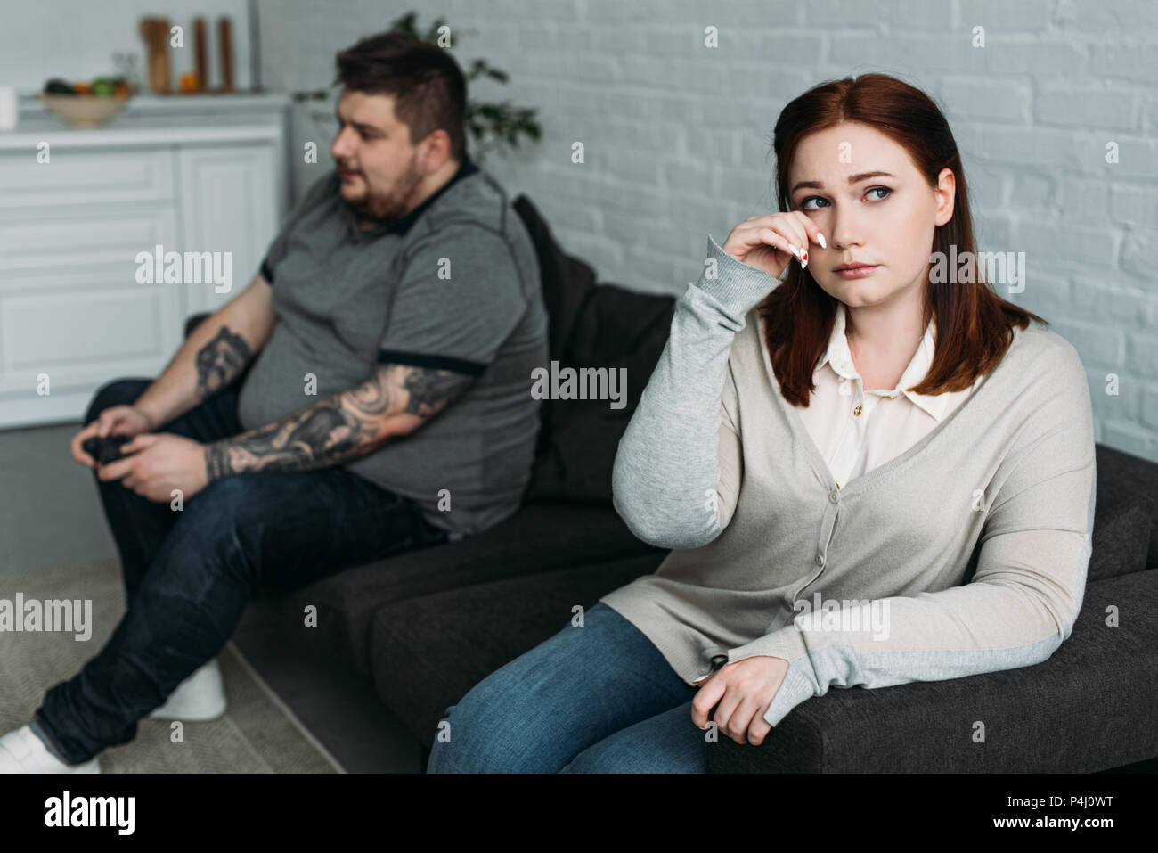 Girlfriend Crying And Boyfriend Playing Video Game At Home Stock