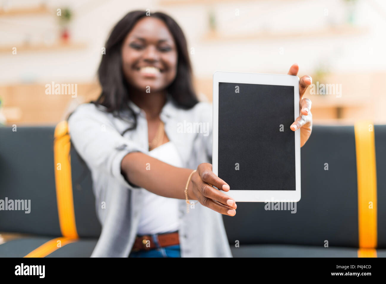 smiling african american woman presenting digital tablet with blank ...