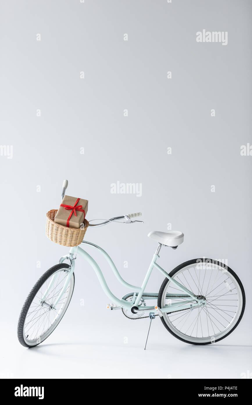 close up view of retro bicycle with wrapped christmas gift in basket isolated on grey Stock Photo