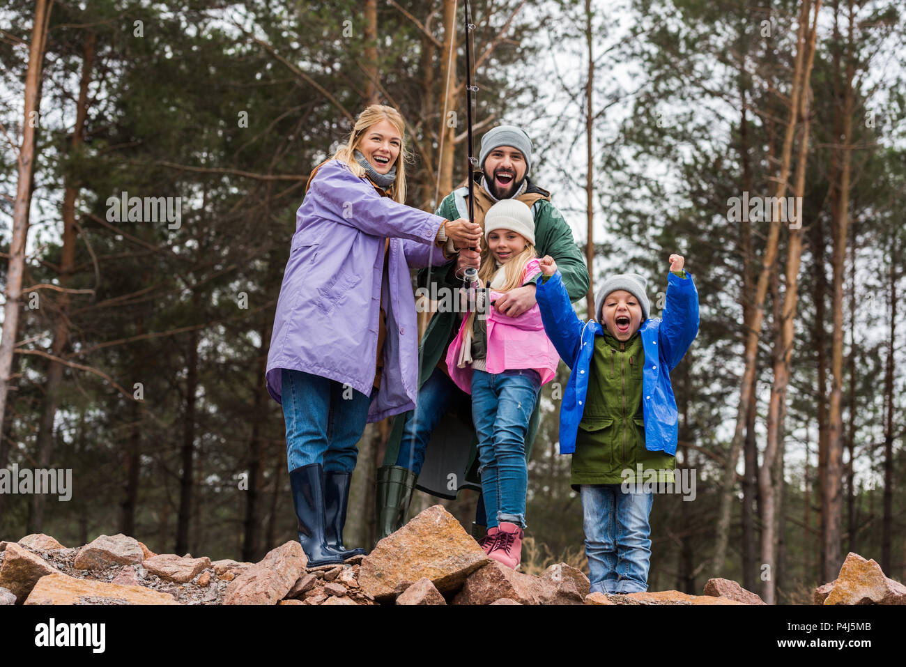 happy young family fishing together at forest lake Stock Photo Alamy