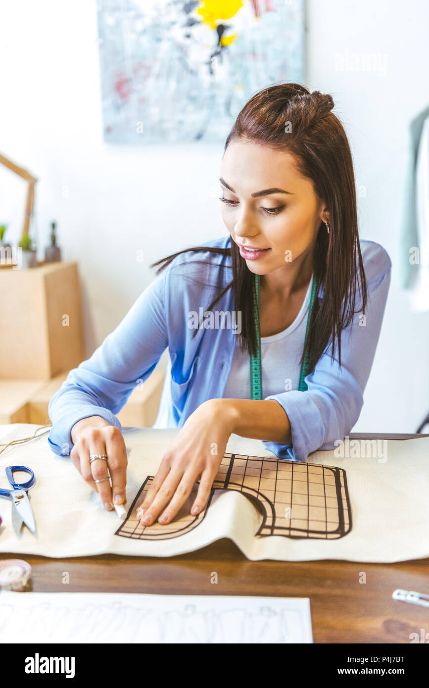 beautiful seamstress marking pattern with piece of chalk Stock Photo