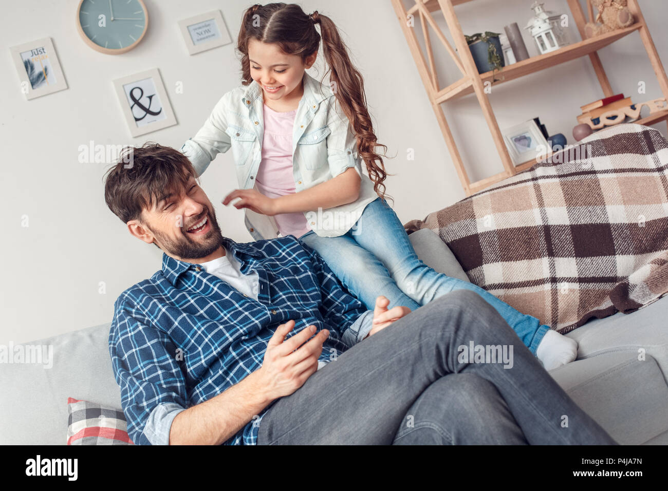 Bearded Man And Little Girl At Home Family Time Sitting On Sofa