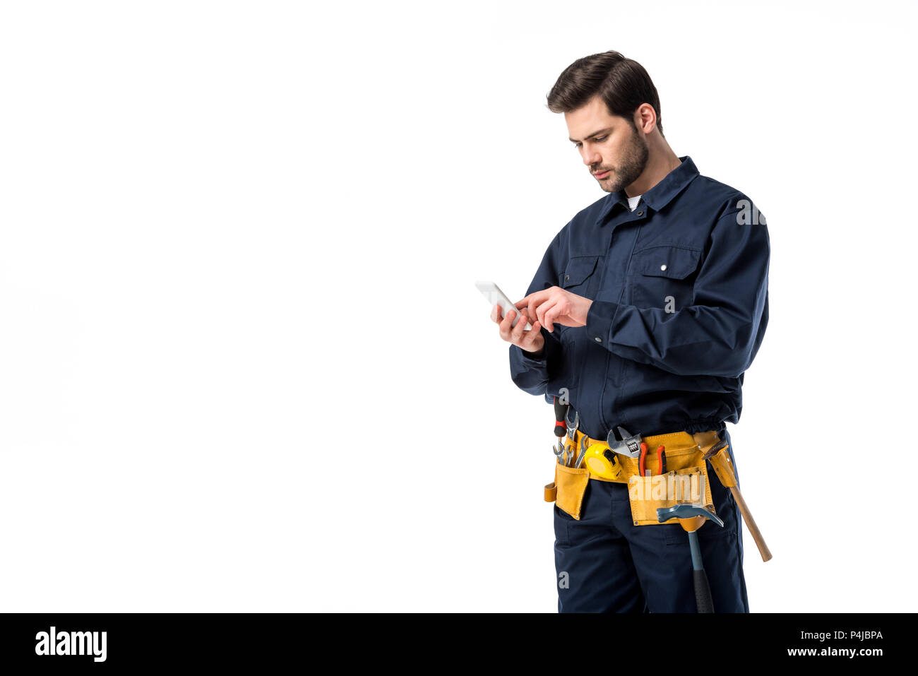 Professional plumber with tool belt using smartphone isolated on white Stock Photo