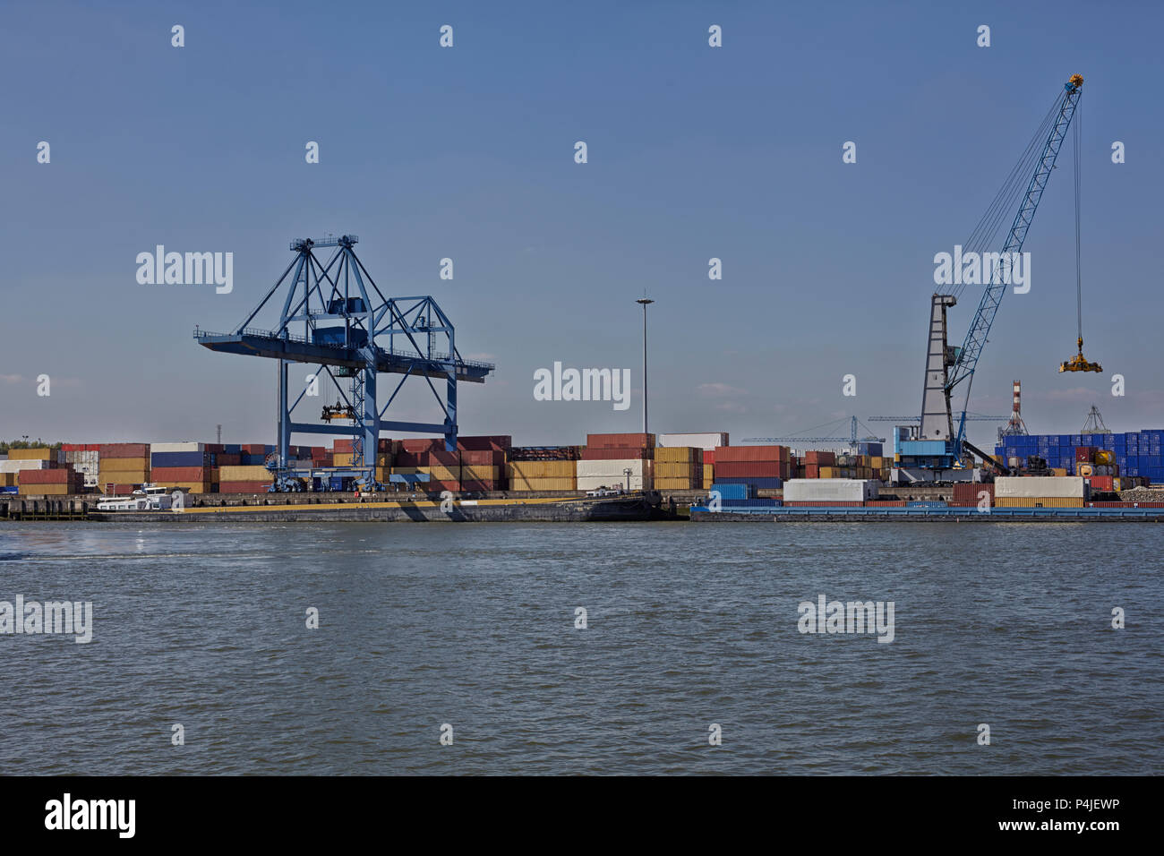 Large harbor cranes at the port of Rotterdam moving big metal
