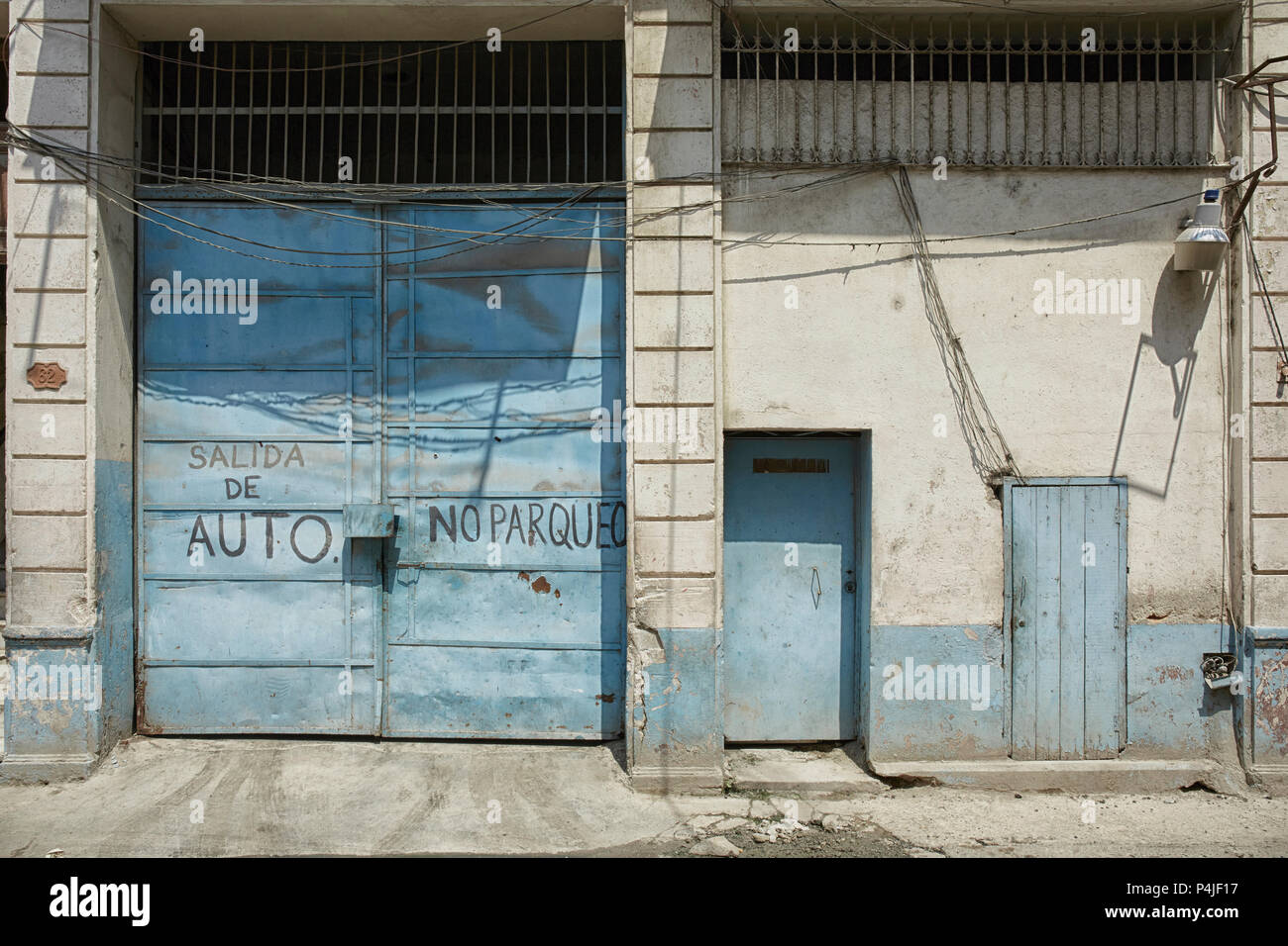 Blue rundown Garage door in Havana, Cuba Stock Photo