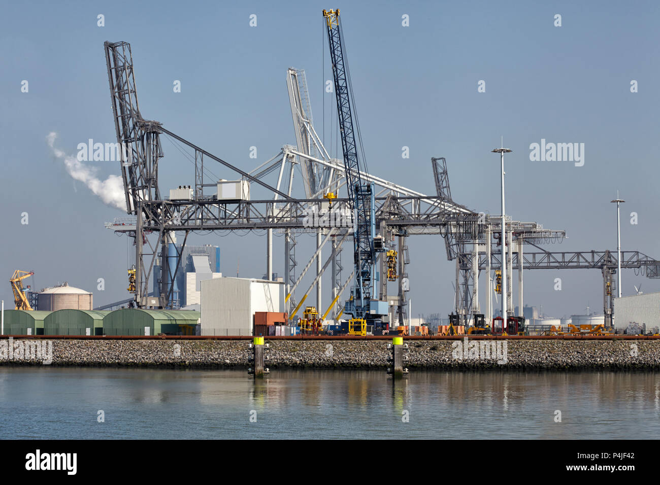 Large harbor cranes at the port of Rotterdam moving big metal