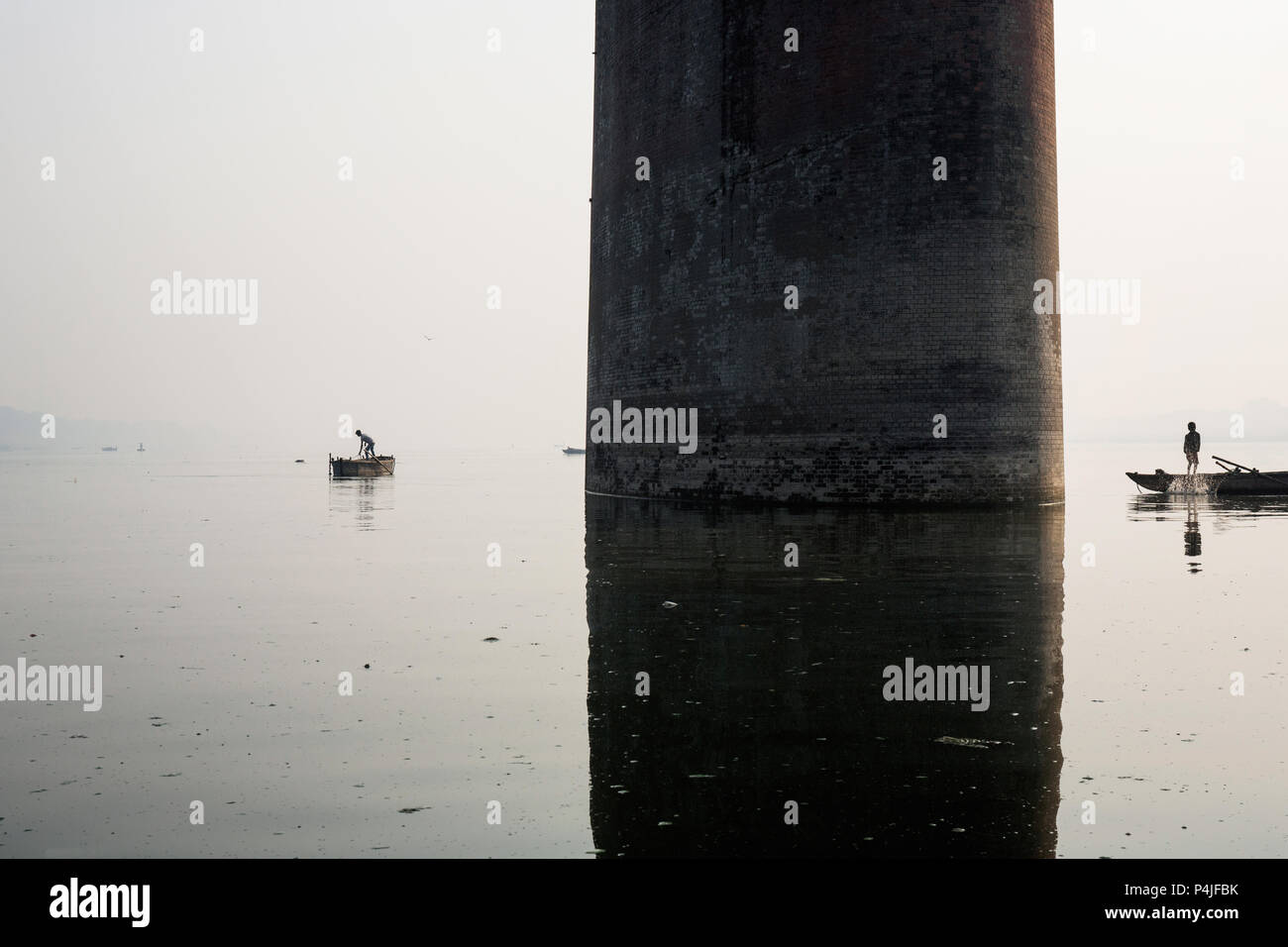 Fishing boat silhouette with Mawlamyine Malviya Bridge background Stock Photo
