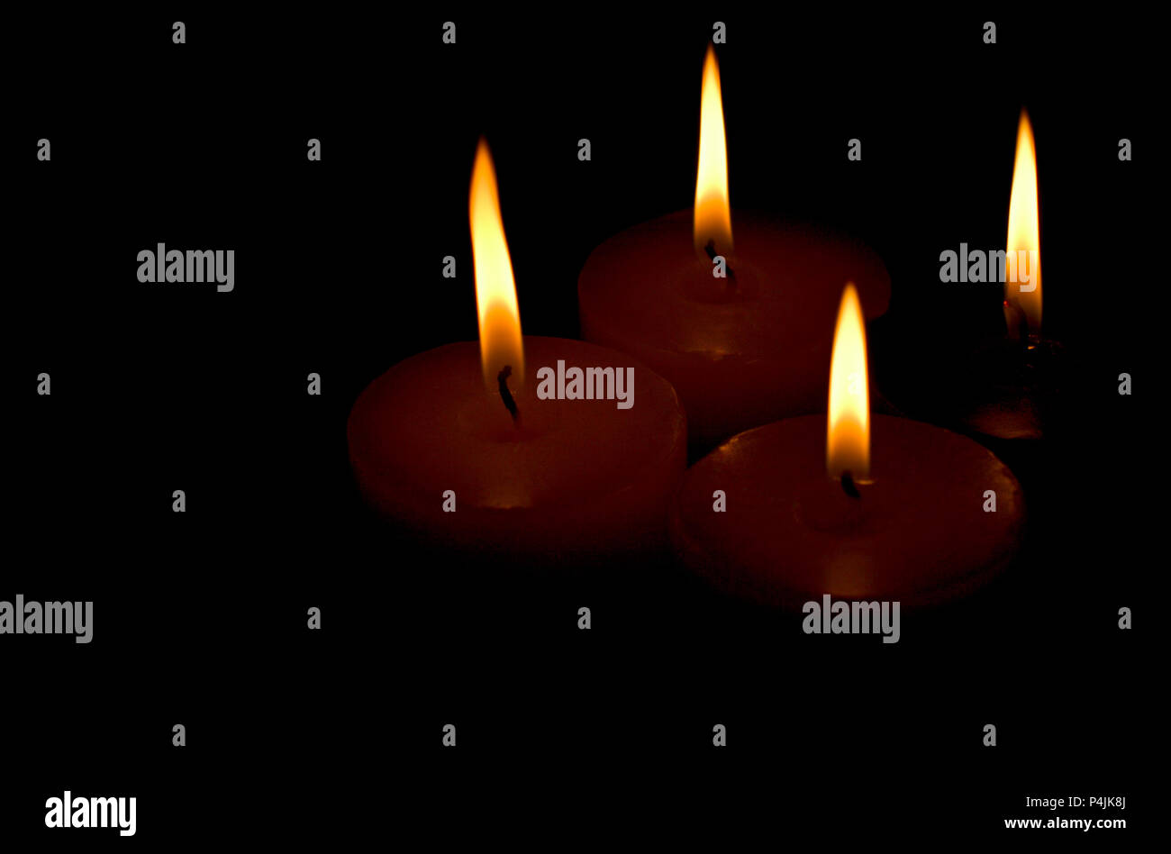 four candles on black background Stock Photo Alamy