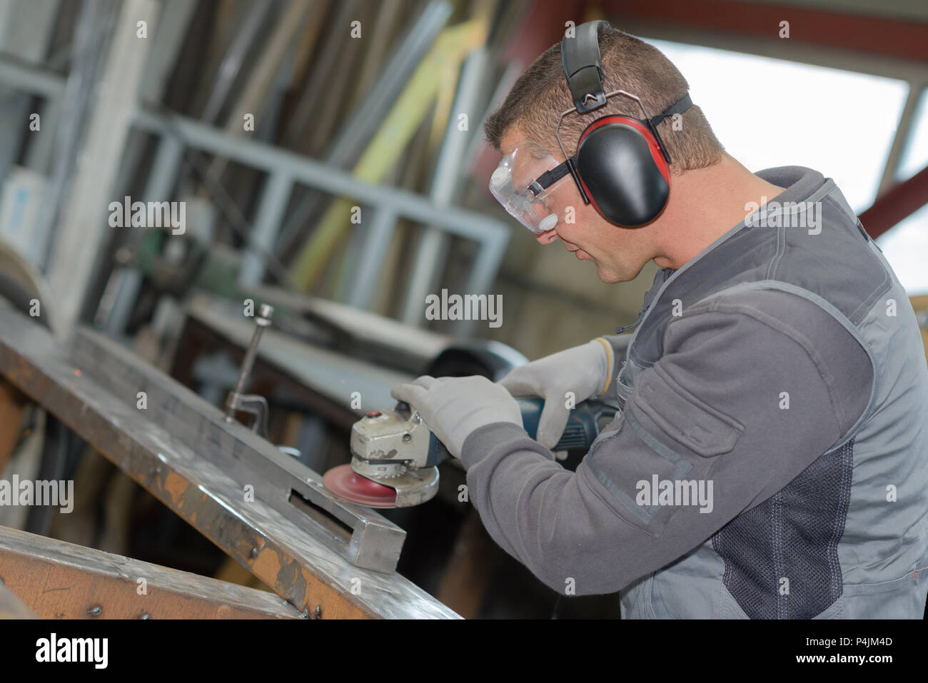Worker using angle grinder Stock Photo - Alamy