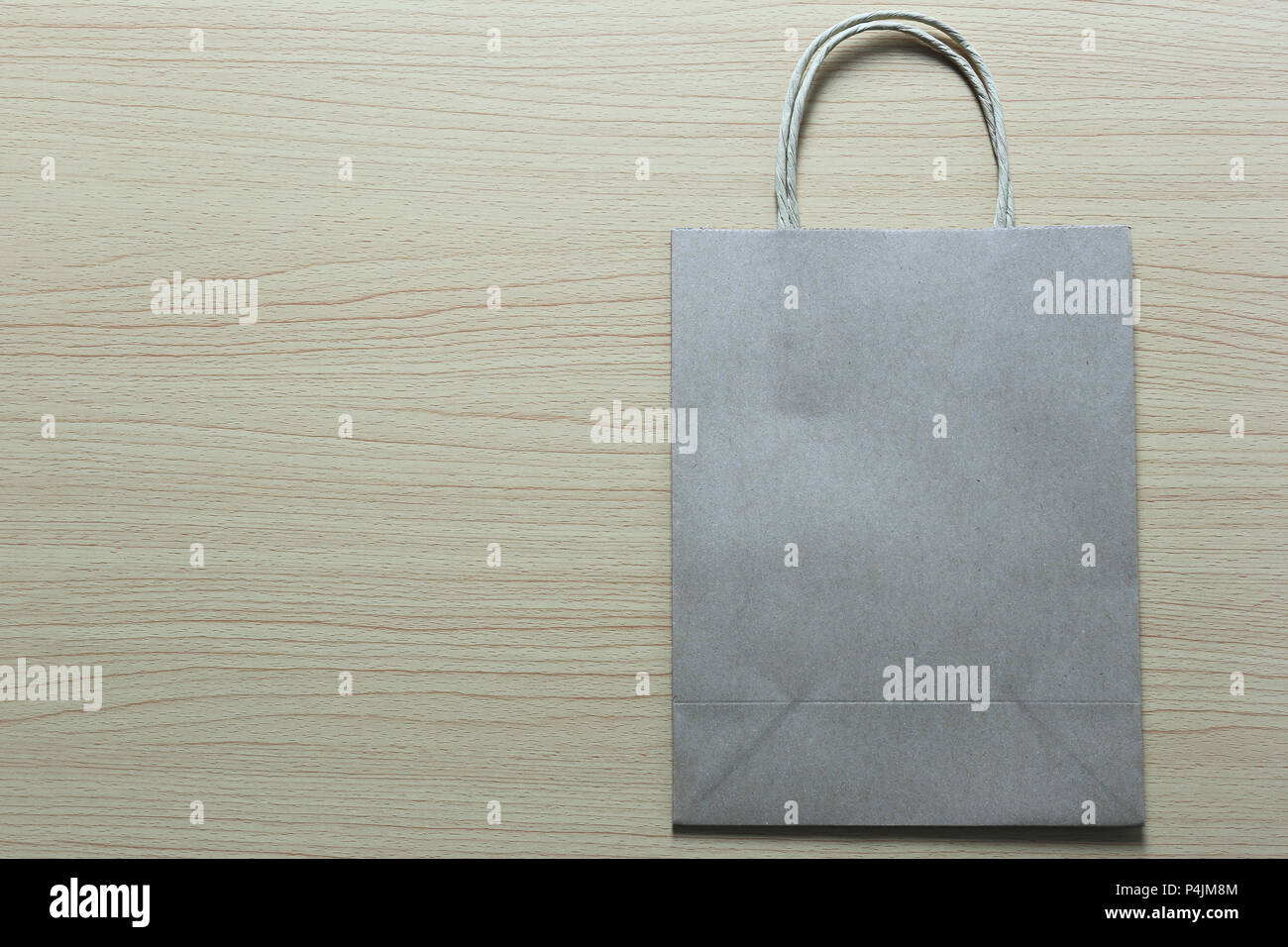 Brown Paper bag is placed on a brown wooden floor and have copy space ...