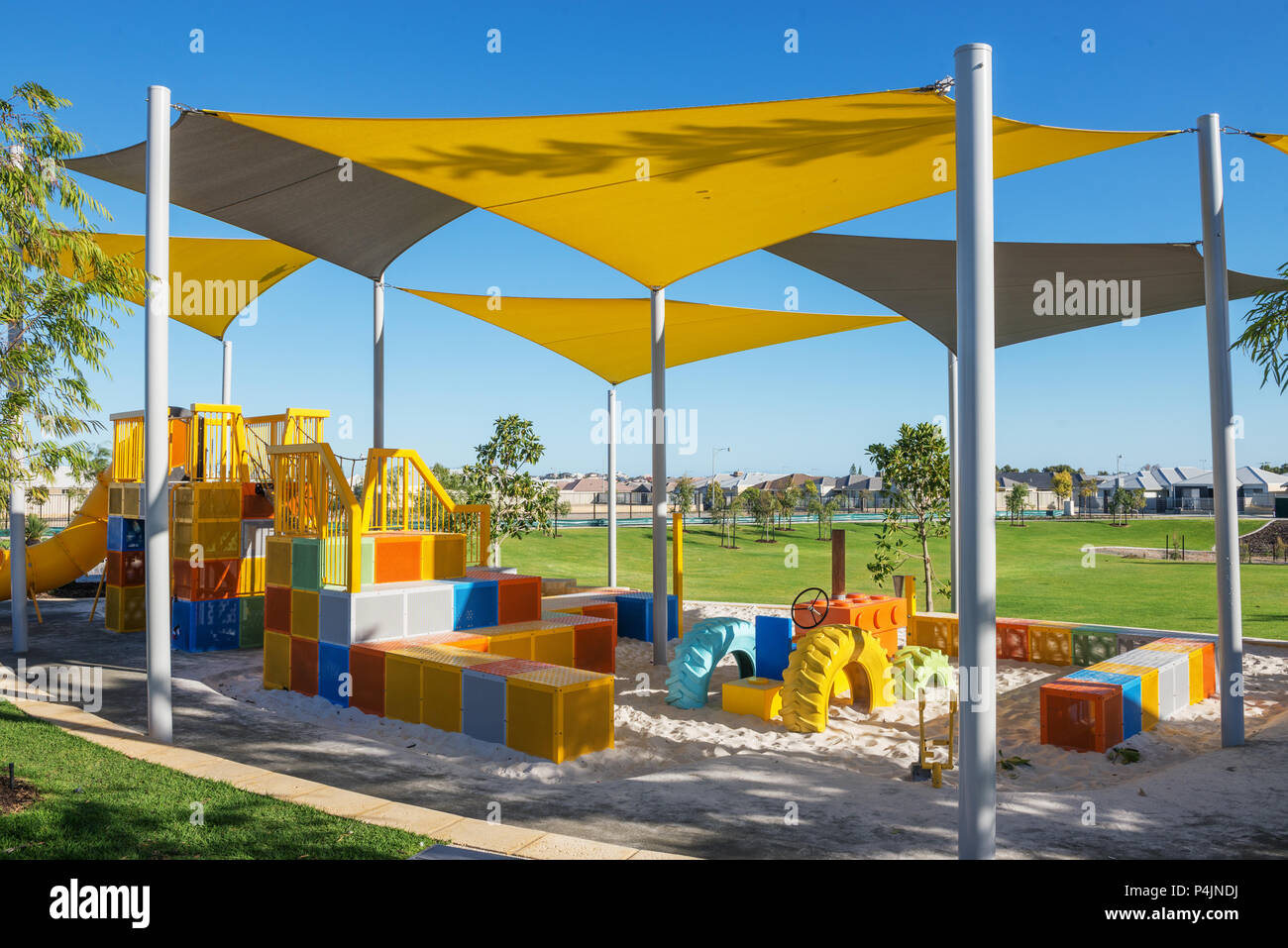 suburban outdoor colorful playground with green grass lawn on background in the morning Stock Photo