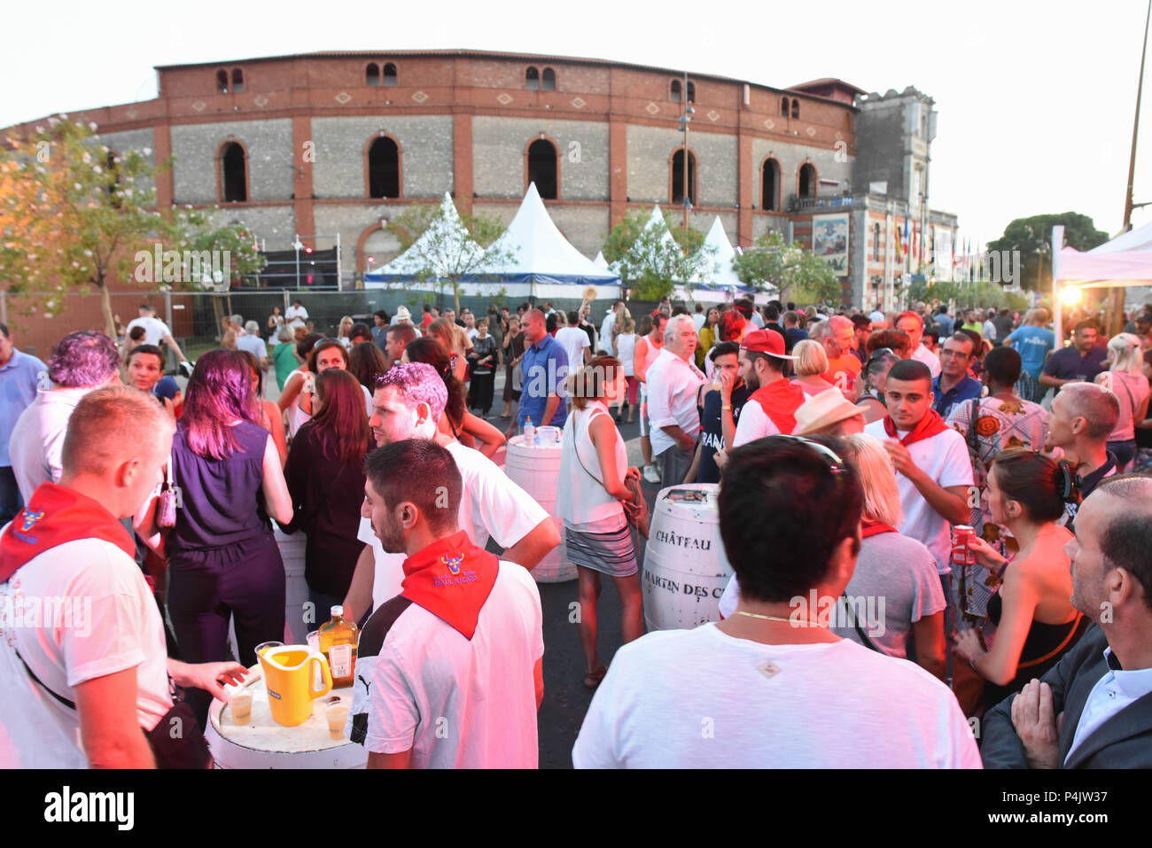 August 12, 2015 - Beziers, France: Beziers townspeople drink outside the bullfighting arena on the first day of the 'Feria', a summer festival of street parties and bullfighting. The town's new mayor, Robert Menard, has allowed the large public mass to take part in the arena as part of his municipal programme to reinvigorate the town's Catholic traditions.  Rassemblement festif a l'exterieur des arenes de Beziers pendant la feria. Stock Photo