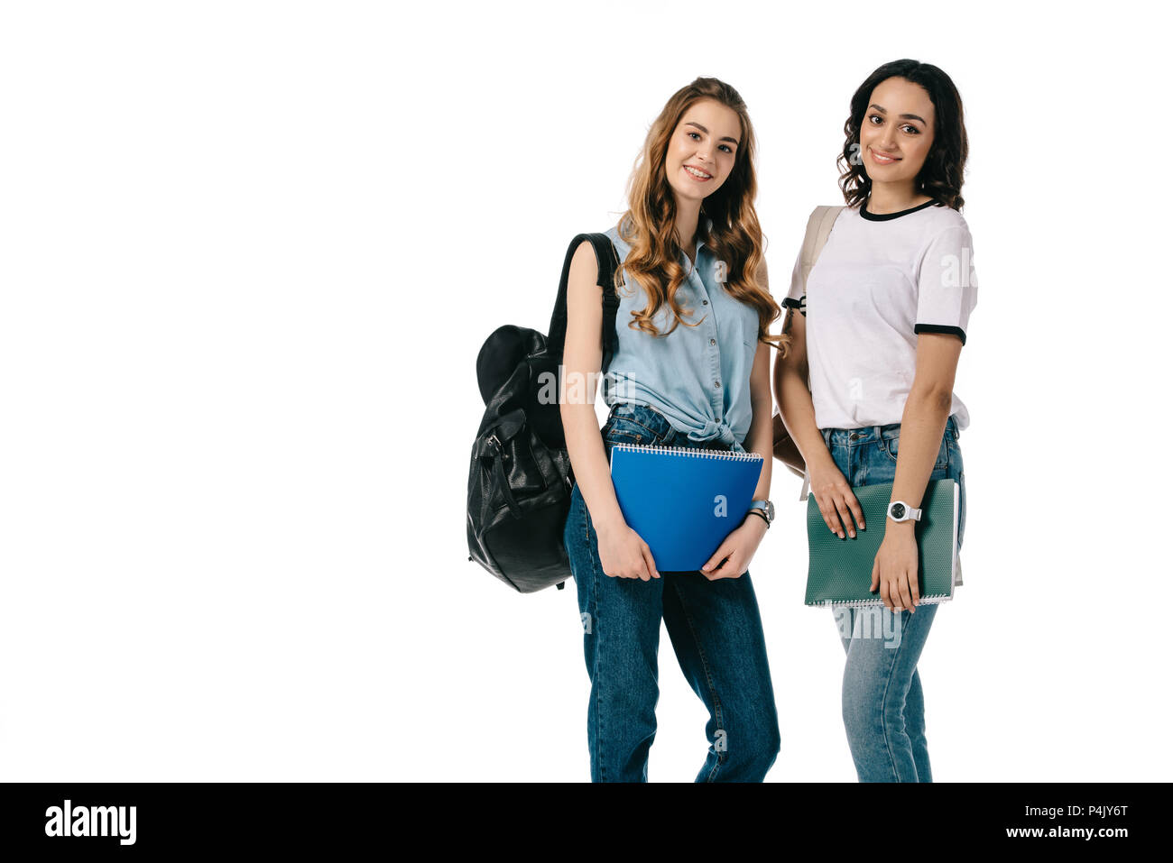 smiling multicultural students holding copybooks and looking at camera ...