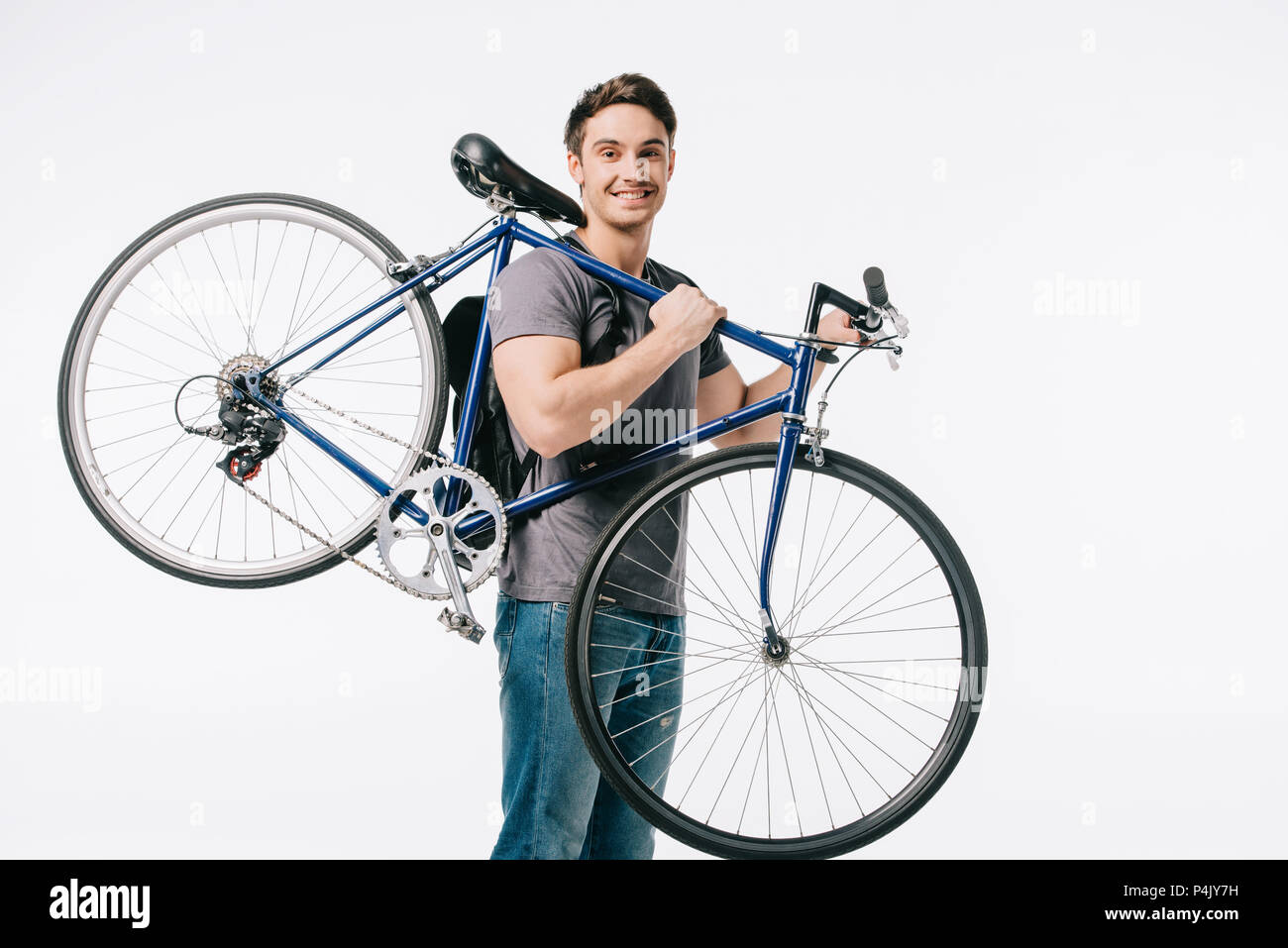 smiling handsome student holding bicycle on shoulder isolated on white Stock Photo