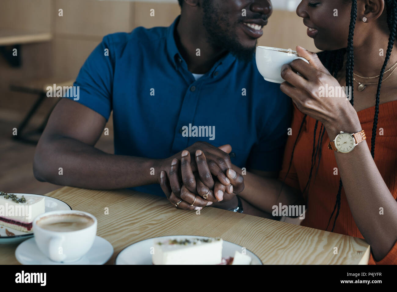 partial view of smiling african american couple holding hands on ...