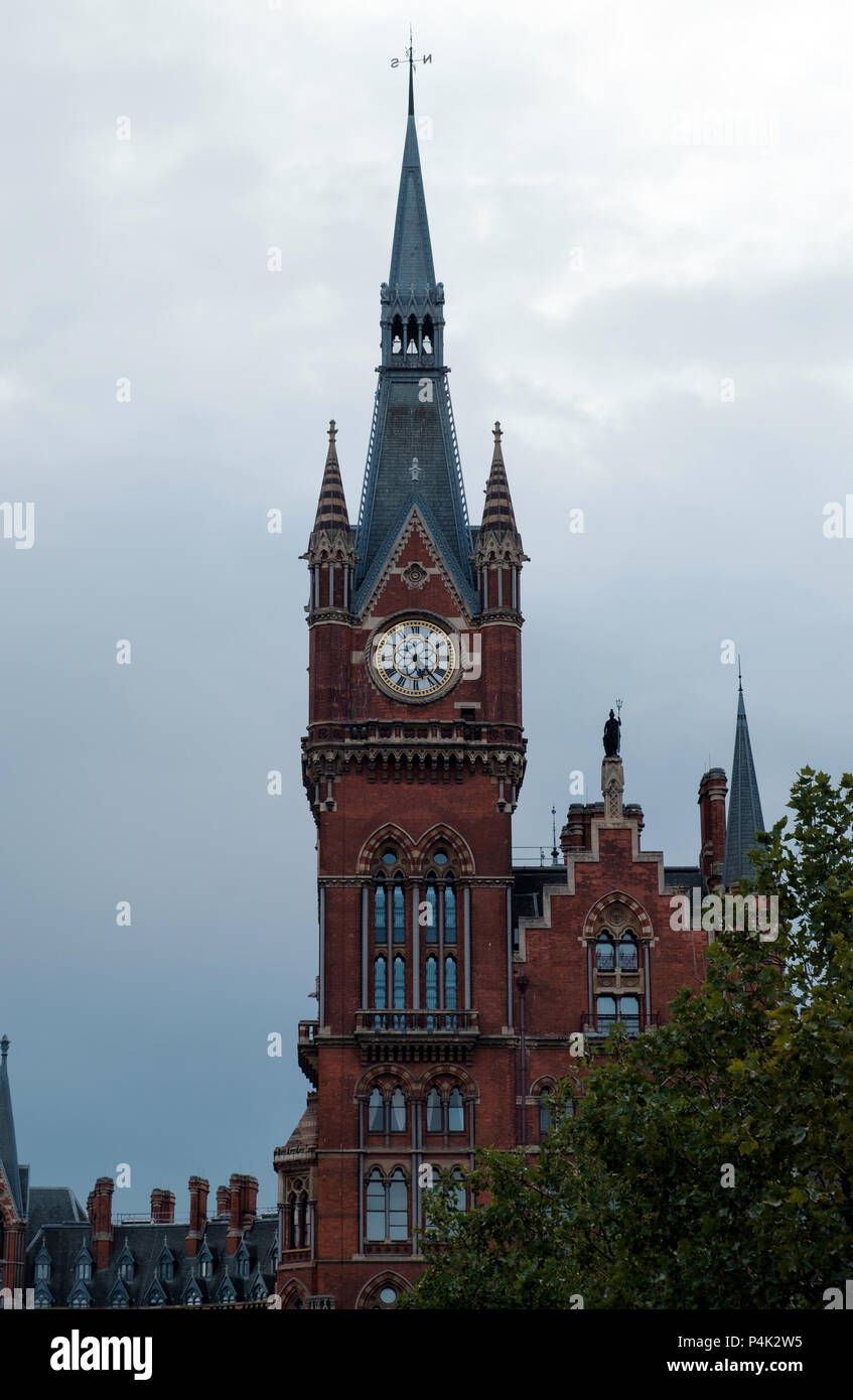 Spired clock tower at St. Pancras International Train Station, St. Pancras Kings Cross, London. Trees in foreground, portrait, copy space. Stock Photo