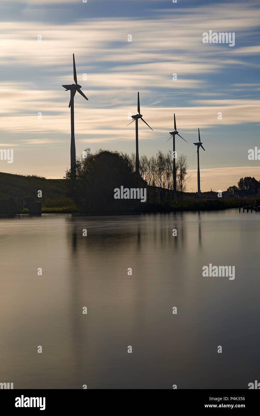 Long exposure of wind turbines with the movement of the clouds made visible to show the power of the wind to generate renewable clean energy Stock Photo