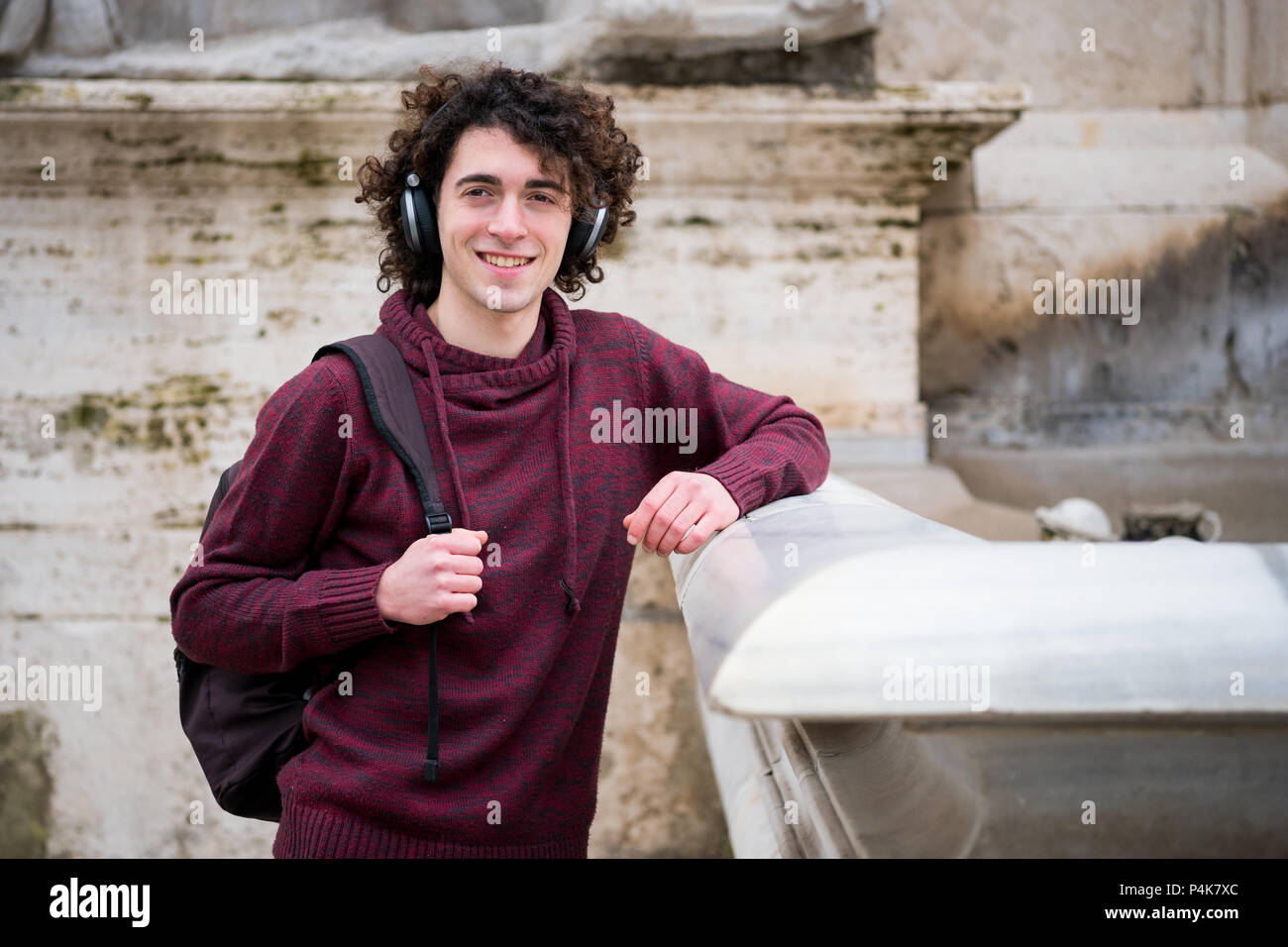 Handsome young man with curly hair and headphones on his head listening the music Stock Photo