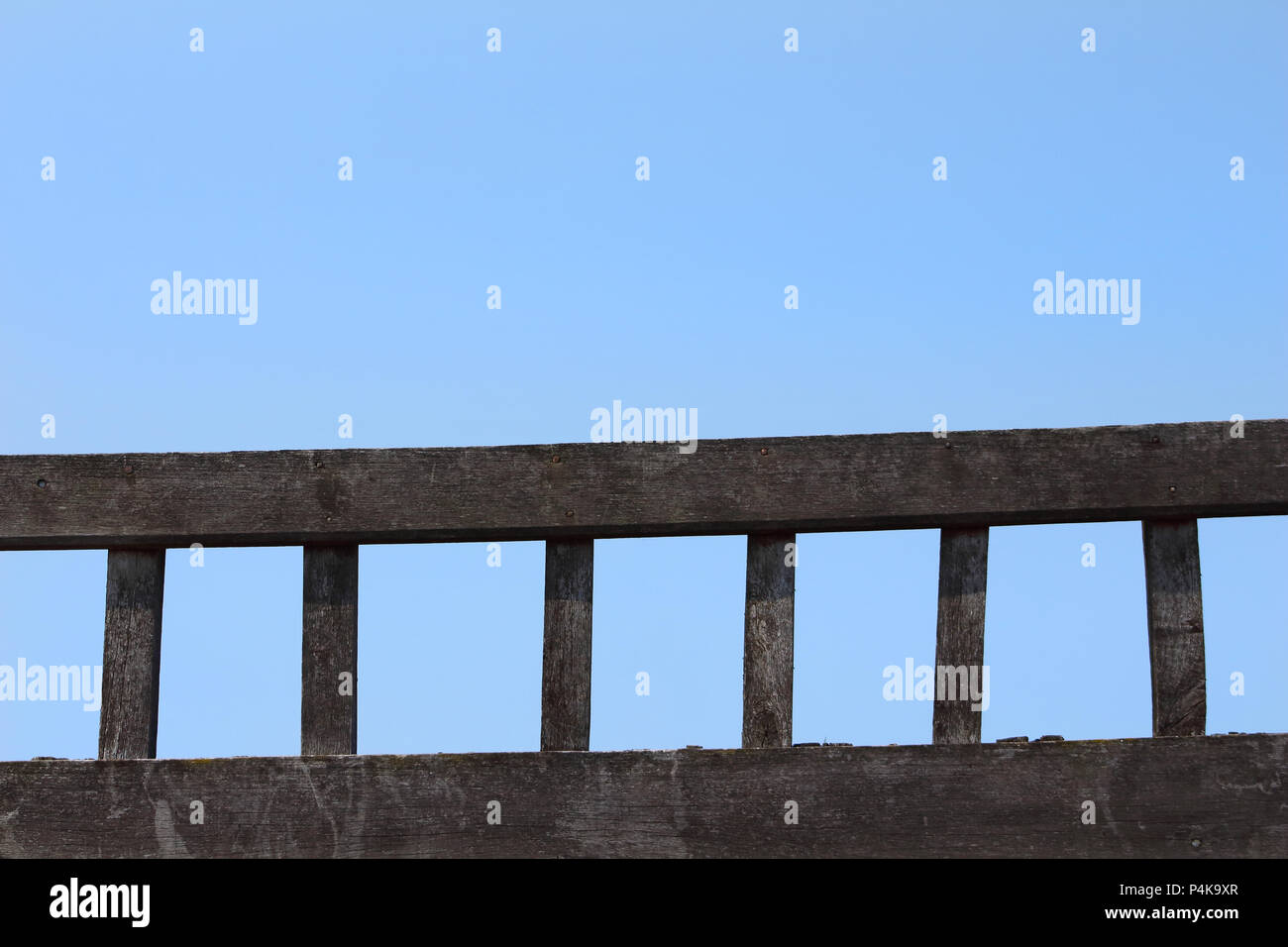 a ladder of old wood laid against a background of blue sky Stock Photo