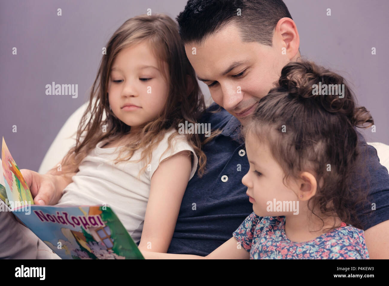 Daddy Reading His Two Little Girls the Stories Stock Photo