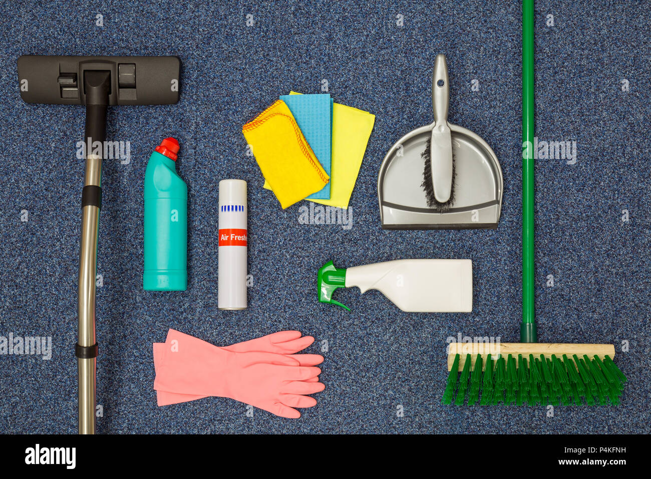 A flat lay arrangement of cleaning equipment on a blue office carpat background. Stock Photo