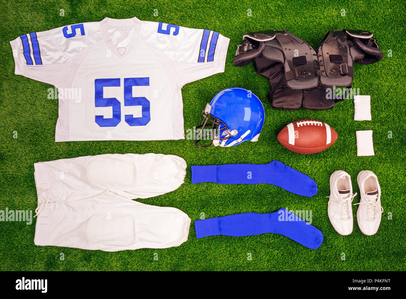 A flat lay arrangement of an Americam Football kit with ball, shirt, helmet and protective pads. Stock Photo