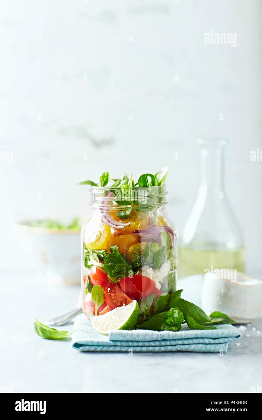 Cherry tomato salad with corn salad and mozzarella in a jar Stock Photo