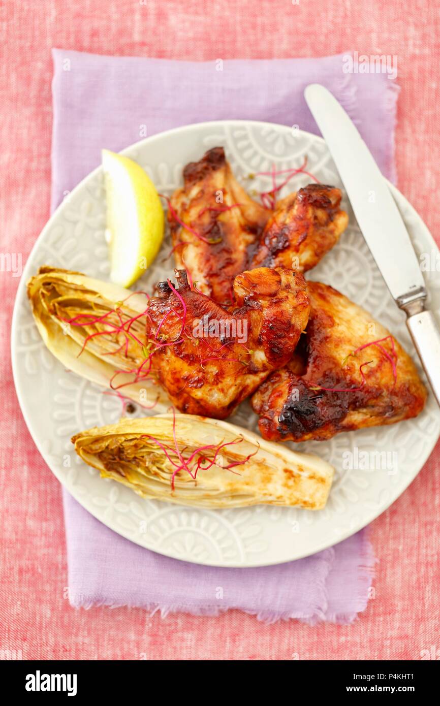 Grilled chicken wings with baked chicory Stock Photo - Alamy
