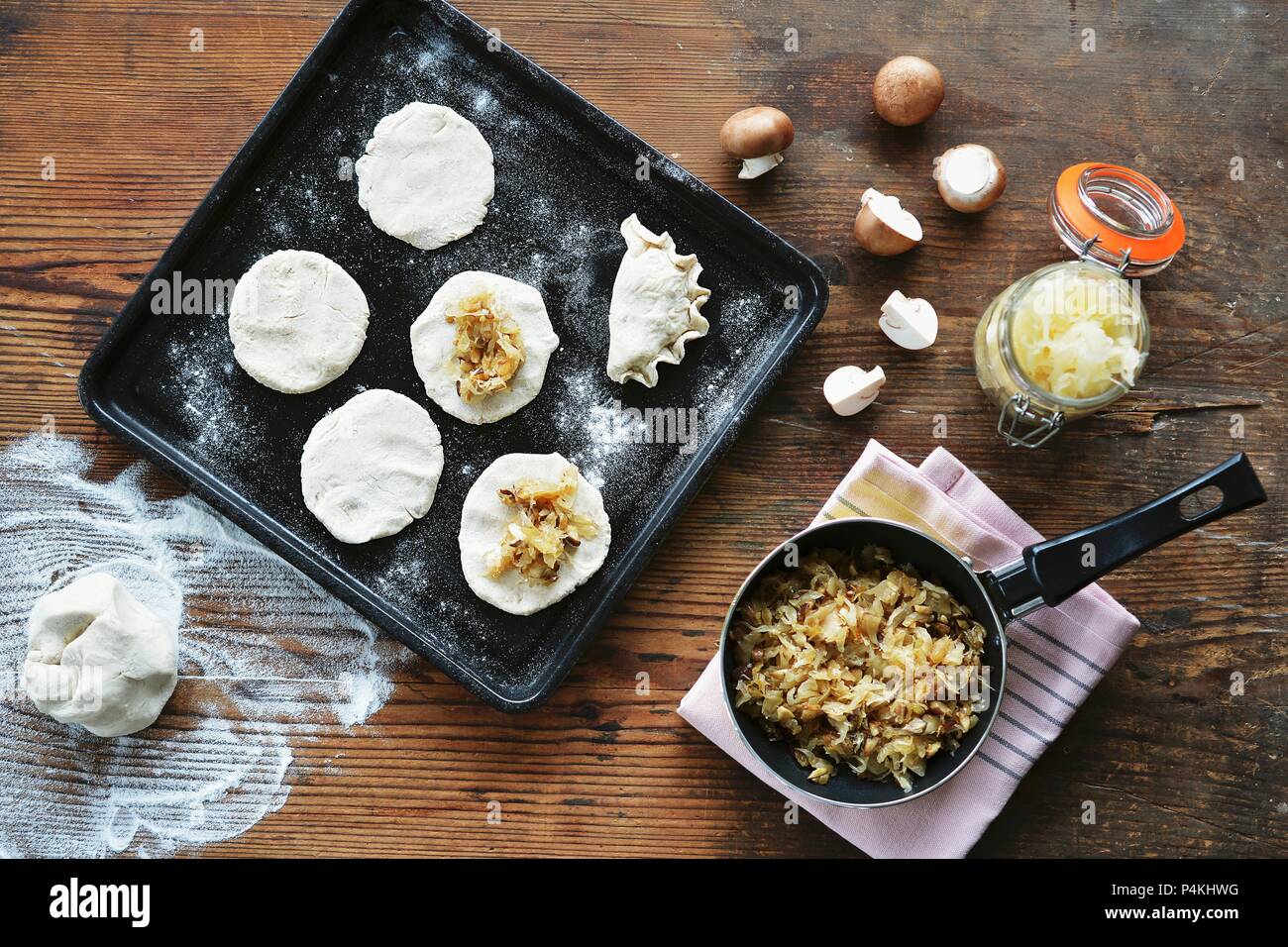 Maultaschen (German pasta dish) on a baking sheet, with dough and ingredients beside it Stock Photo
