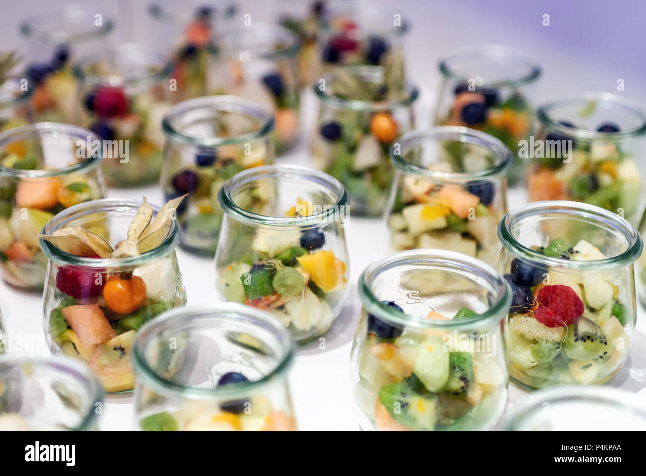 Closeup many dessert jar rowed up on a buffet table with fresh fruits jelly and cream Stock Photo